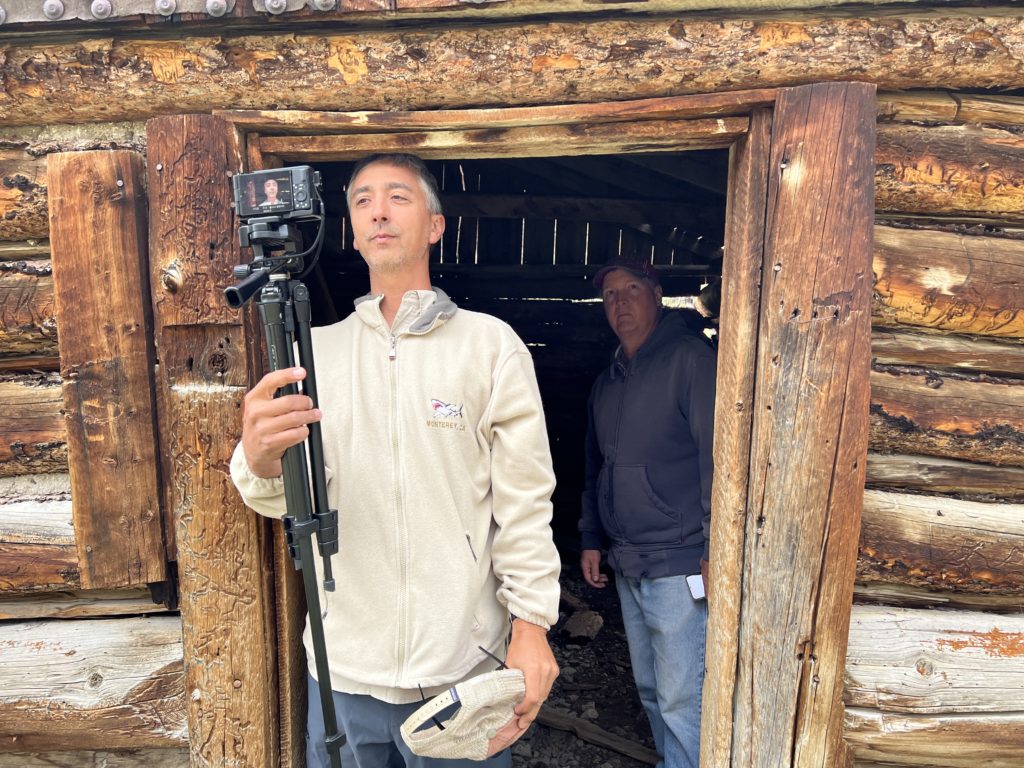 Aaron Linsdau and Elgin Cook stand in a cabin in Kirwin, Wyoming