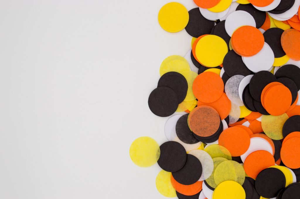 Yellow, black, orange and white dots of tissue paper sprinkled on the table