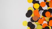 Yellow, black, orange and white dots of tissue paper sprinkled on the table