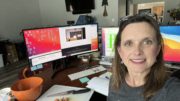 Melissa Cook sitting at her desk with two monitors.