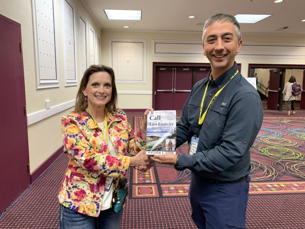 Melissa Cook presents "The Call of the Last Frontier" to endorser Aaron Linsdau.