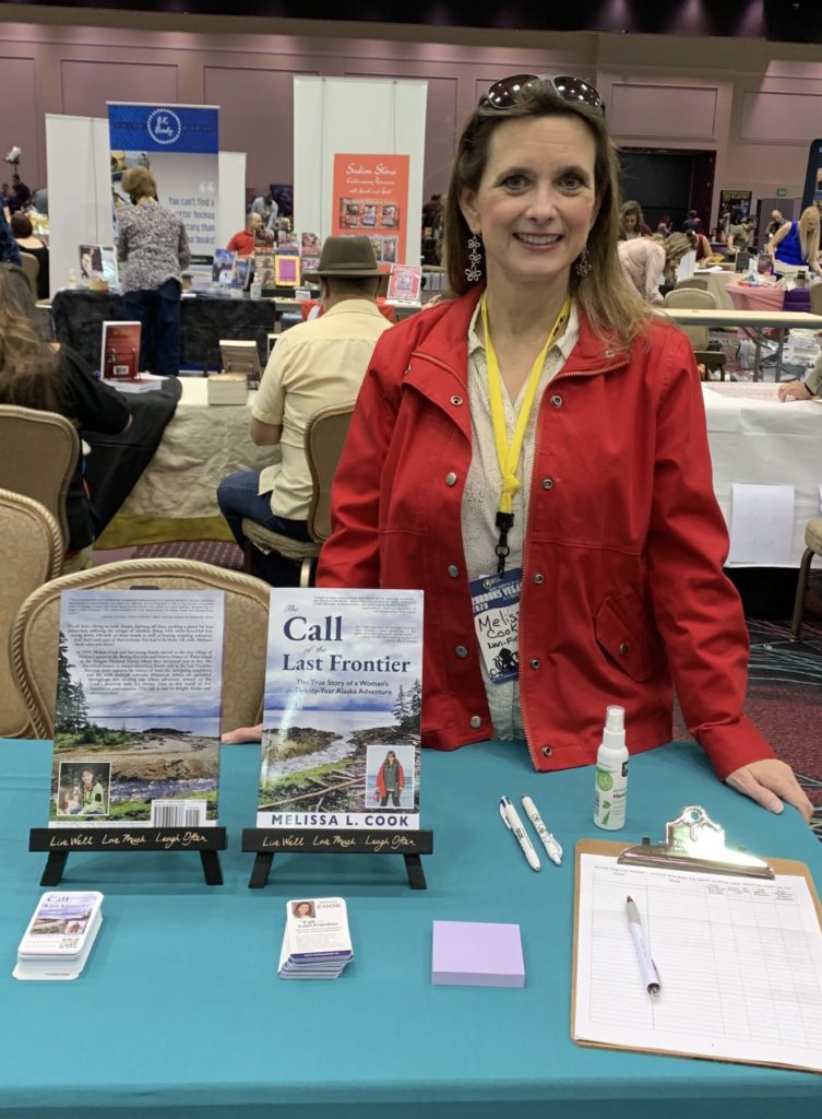Author Melissa Cook stands with "The Call of the Last Frontier" in Las Vegas 2021