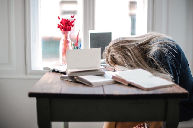 Woman with head on desk from fatigue