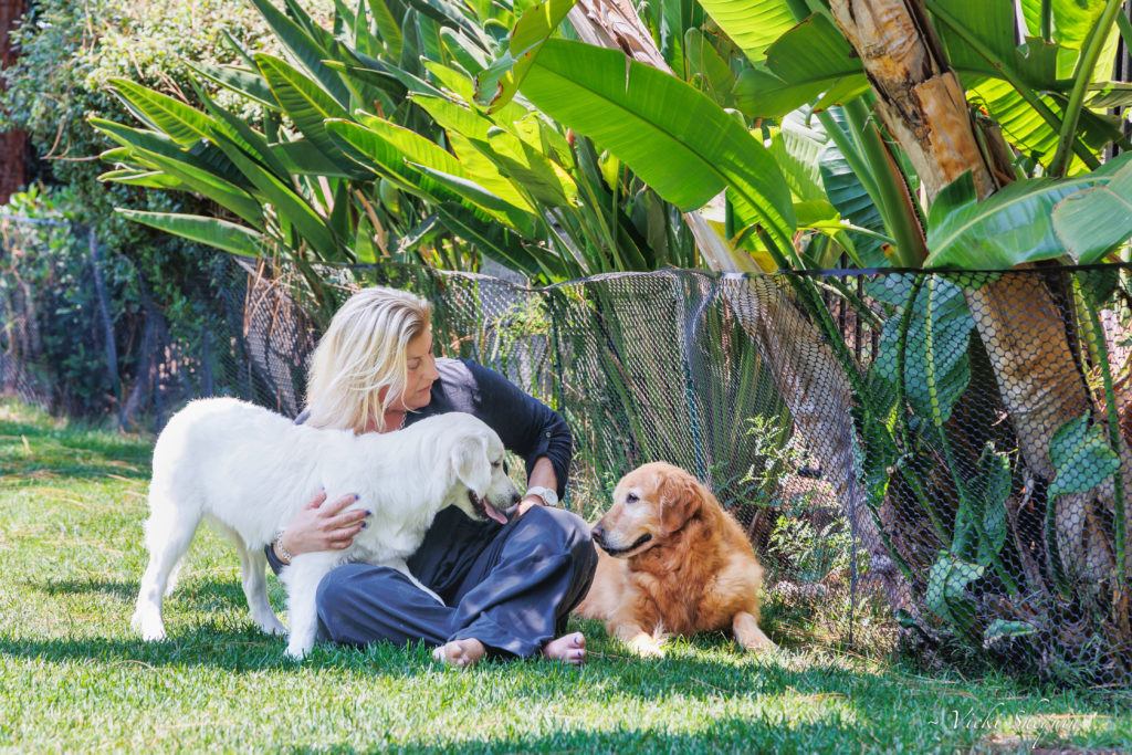 Jenn Powell, MS podcaster and advocate, sits on the lawn with her two dogs
